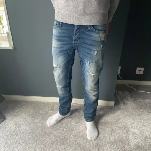 Jack & Jones jeans med slitningar - Ett par tvär feta Jack & Jones Jeans med en snygg tvätt och slitningar👖| Skick 9,5/10✅| Modell: Slim- Glenn🙌| Hör av er vid ytterligare frågor❗️