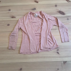 Rosa kofta från Zara Girl's - Säljer en söt rosa kofta från Zara Girl's som är perfekt för sommaren. Den är i ett mjukt och lätt material med långa ärmar och en öppen design framtill. Perfekt att slänga på sig under svala sommarkvällar. 🩷