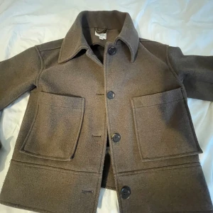 Brun kappa från kappahl - Säljer denna jättefina mörkbruna kappan från Kappahl❤️ Använd ganska mycket och är lite nopprig, men inget man tänker på. Perfekt nu till hösten och vintern❤️