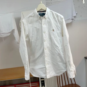 Vit skjorta Polo Ralph Lauren - Säljer en klassisk vit skjorta från Polo Ralph Lauren. Perfekt för både vardag och fest! Storlek M i perfekt skick. Skriv PM vid minsta fråga.