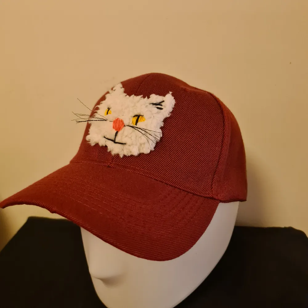 Hand customised baseball cap with cat detail and embroidered logo. This is a handmade customised item. . One of a kind. One size fits all with adjustable velcro strap fixing. . Accessoarer.