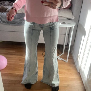 Ljusblå bootcut jeans - Säljer ett par snygga ljusblå bootcut jeans i mycket bra skick. De är lågmidjade och har en cool vintage look med framträdande sömmar och fickdetaljer. Perfekta för både vardag och fest! 