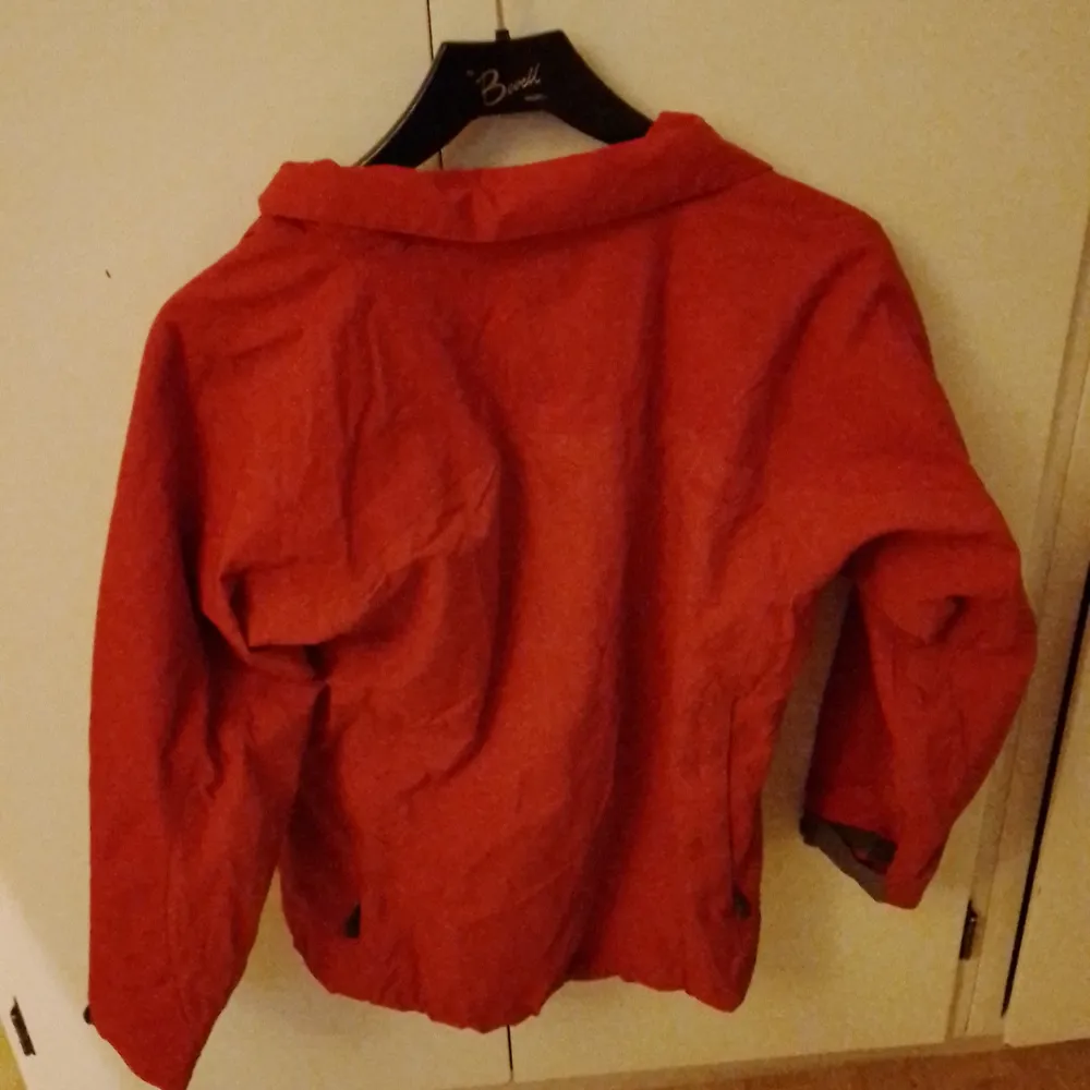 Röd jacka från didriksons i storlek 150. Gissar att den är till våren eller bara en vindjacka då den är tunn. Katt finns I hemmet. Takit.