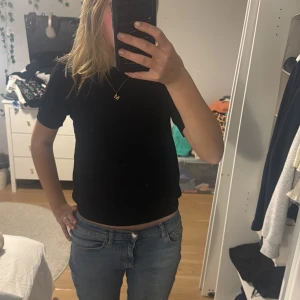 Svart kortärmad topp - Säljer en enkel och stilren svart kortärmad topp. Perfekt för vardagsbruk eller att klä upp med accessoarer. Toppen har en normal passform och är gjord i ett mjukt och bekvämt material.