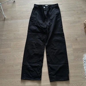 Weekday  vida chinos strlk 46 - Säljer ett par svarta byxor bra skick. De har en loose passform och är tillverkade i ett robust material. Byxorna har en hög midja och stilrena bakfickor med knappdetaljer. Strl 46