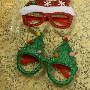 Barn Juliga glasögon i glitter - Säljer superfestliga julglasögon i glittrigt rött och grönt. Ett par har en tomteluva med snöflingor, ett annat par har renhorn med pom-poms, och ett par har en julgran med färgglada bollar. Perfekta för julfesten eller som en rolig accessoar under julhelgen! 🎄🎅    89kr/2st 