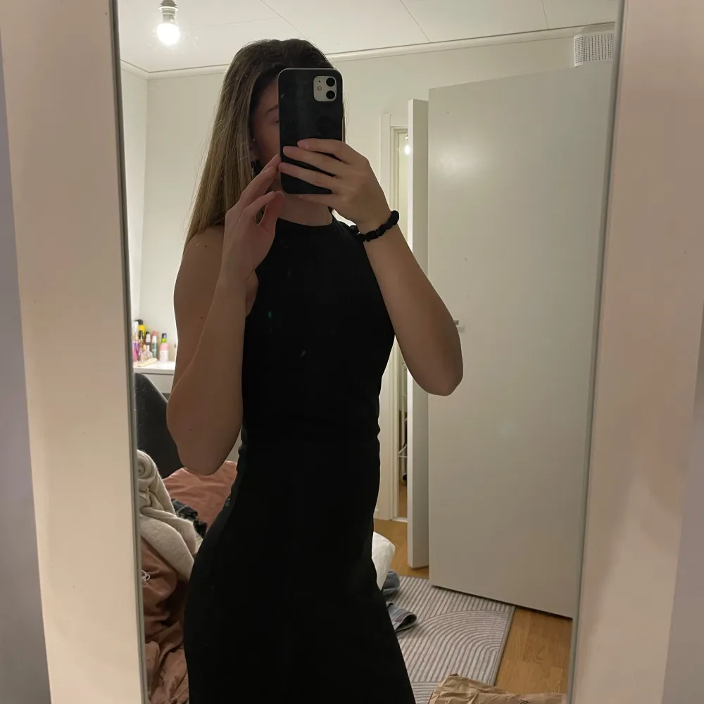 Säljer en elegant svart långklänning i mycket bra skick. Klänningen har en tight passform och är ärmlös, perfekt för festliga tillfällen. Den är stilren och kan enkelt matchas med olika accessoarer för en komplett look.. Klänningar.