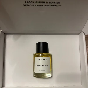 Essnce Carashmellow Parfym - Säljer en flaska Essnce Carashmellow parfym. Den kommer i en stilren glasflaska med svart lock och en etikett i vitt med svart text. Doften är en Eau de Parfum, perfekt för dig som gillar en söt och unik doftprofil. Flaskan ligger i en elegant förpackning med texten 'A good perfume is nothing without a great personality'. Enbart testad och kommer med förpackningen. #parym #essnce