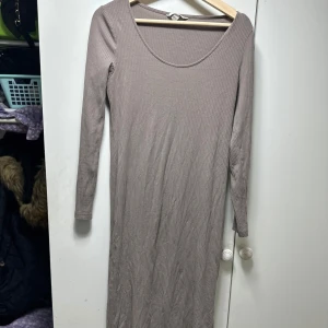 Beige ribbad långklänning - Säljer en superfin beige ribbad långklänning med långärmad design. Perfekt för höst och vår, den är både stilren och bekväm. Klänningen har en enkel men elegant look som passar till många olika tillfällen. Perfekt för dig som gillar en minimalistisk stil!
