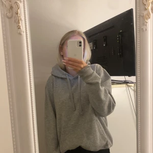 Grå hoodie i mysigt material - Säljer en supermysig grå hoodie i mjukt material. Perfekt för kyliga dagar eller när du bara vill mysa hemma. Den har en klassisk passform med långa ärmar och en stor huva. Ett måste i garderoben för alla som älskar bekväma kläder!