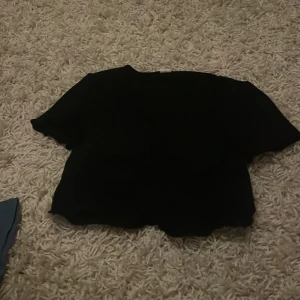 Svart topp från Shein - Säljer en enkel svart topp från Shein i storlek 12Y. Perfekt för vardagsbruk med en bekväm passform. Toppen är kortärmad och gjord i ett mjukt material. Passar bra till både jeans och kjol!