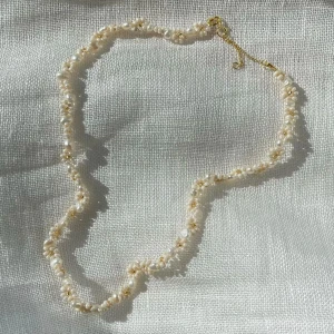 Halsband  - Egengjort pärlhalsband med små vita pärlor och gulddetaljer.✨️ Halsbandet har en justerbar kedja för att passa olika längder. 