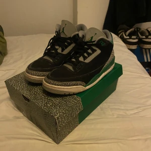 Jordan 3 Retro Pine Green - Säljer ett par Jordan 3 Retro Pine Green i svart och grönt. Perfekta för kallare dagar. Skorna är i mycket bra skick (8/10 cond) och kommer med orginalförpackning, köpta på stock x kvitto finns. Priset är ej hugget i sten !!