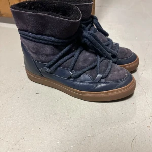 Mörkblå boots från Inuikii - Säljer ett par mörkblå boots från Inuikii i bra skick. De har en snygg kombination av skinn och mocka med en robust gummisulan brunt. Perfekta för höst och vinter!