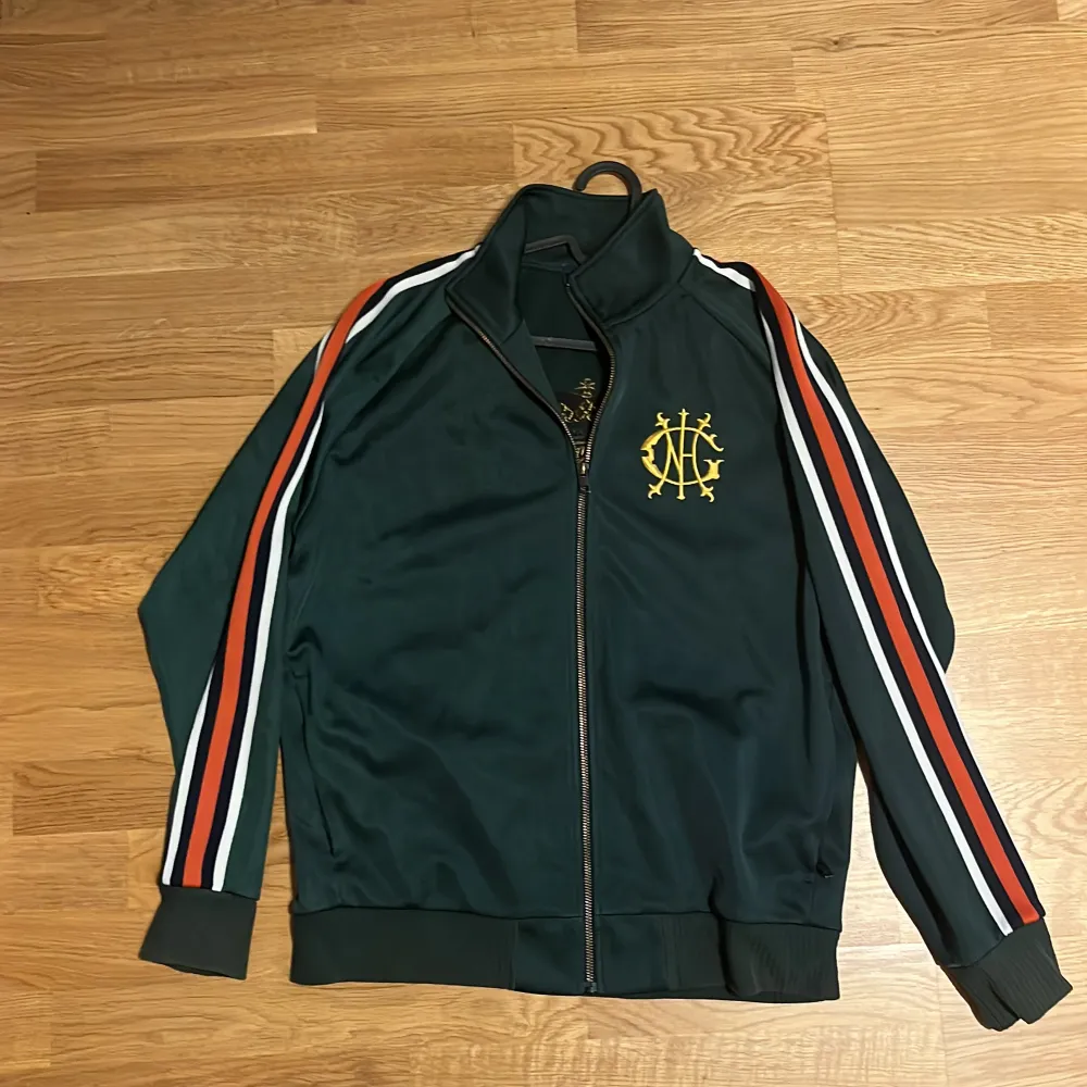 Säljer en grön track jacket från GANT i storlek S. . Jackor.