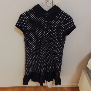 klänning  Polo Ralph Lauren - 💙Säljer min marin blå klänning med vita prickar från Ralph Lauren. Den har korta ärmar och en krage med knappar framtill. Mått- axelbredd 37,5 cm. Längd 87 cm. Lågt pris för har haft den länge men inte använt så mycket. 