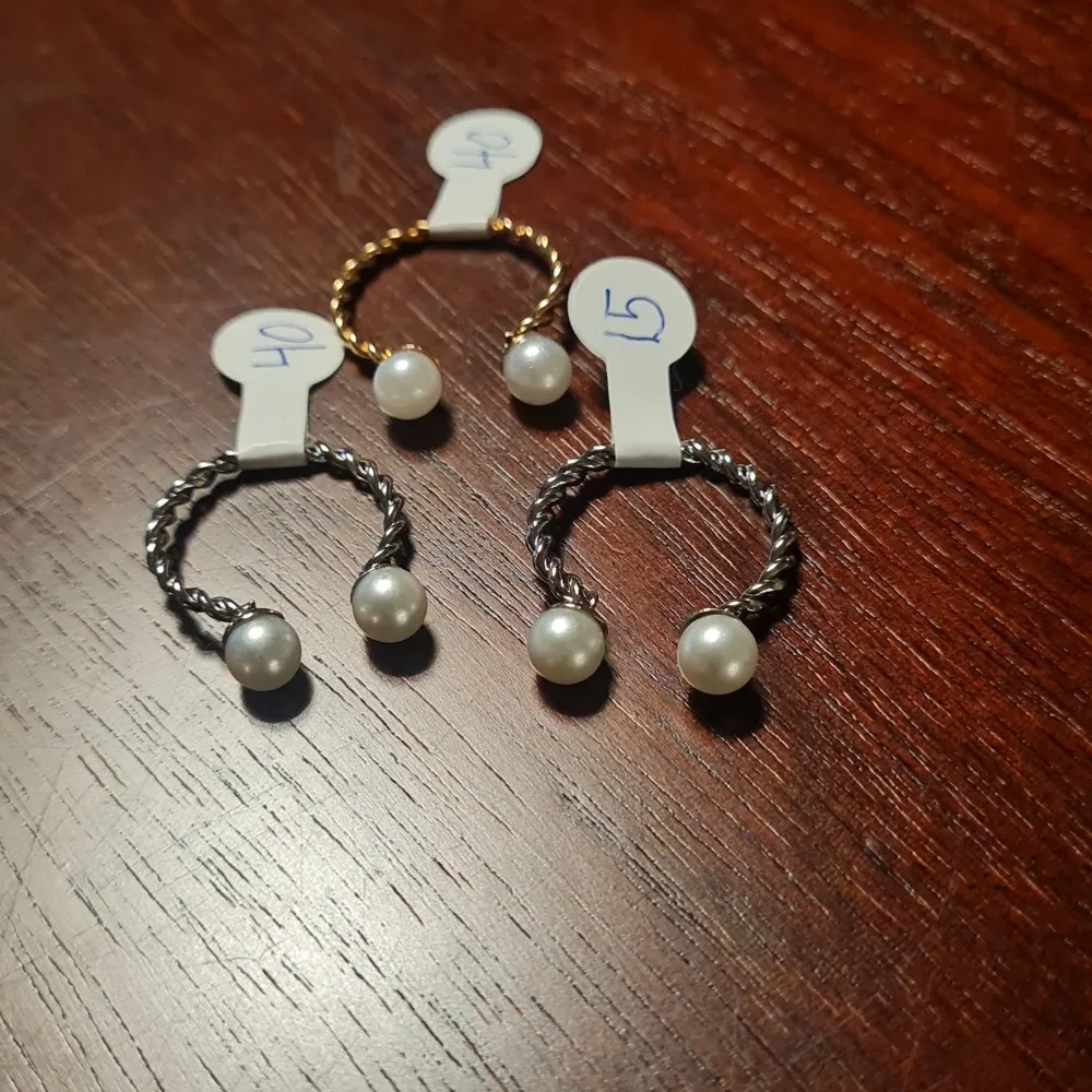 Säljer ett set av eleganta ringar i både silver och guldtoner. De har en vriden design med vackra pärldetaljer som ger en lyxig känsla. Perfekta för att lyfta vilken outfit som helst, oavsett om det är till vardags eller fest. Passar de flesta storlekar. Storlek: 13,14,15,16,19 Pris: 40:-/Styck . Asusteet.