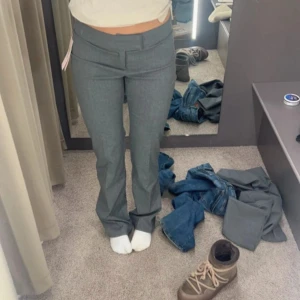 Grå kostymbyxor - Snygga grå kostymbyxor i mycket bra skick. De är lågmidjade och har en elegant straight passform. Byxorna är gjorda i ett bekvämt material som ger en stilren look. Ett måste i garderoben för en klassisk stil! Lite noppriga men inget som jag tänker på💗