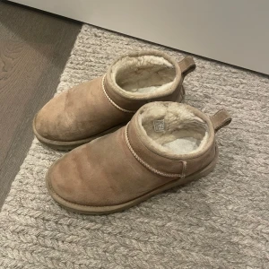 W Classic Ultra Mini Uggs Sand - Mysiga Uggs i storlek 38 i färgen sand. Använda men i bra skick 🤎Slitningar som är mer på ”insidan” kan man se på sista bilden. 