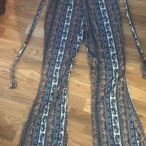 Mönstrade byxor med knytband - Knytband i midjan och en loose passform som ger en avslappnad stil. Köpt från en marknad utomlands så inget märke. 