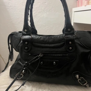 Handväska - Säljer min superfina väska, i fint skick! Spegeln saknas, annars inga defekter. 30cm bredd och 18cm höjd. Axelbandet tillkommer🤍