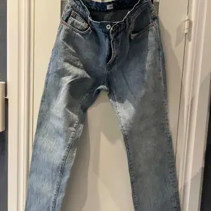 Säljer ett par snygga blå jeans från Woodbird i storlek W31 L34. De har en klassisk straight passform med knappgylf och fem fickor. Perfekta för både vardag och fest! 🕺