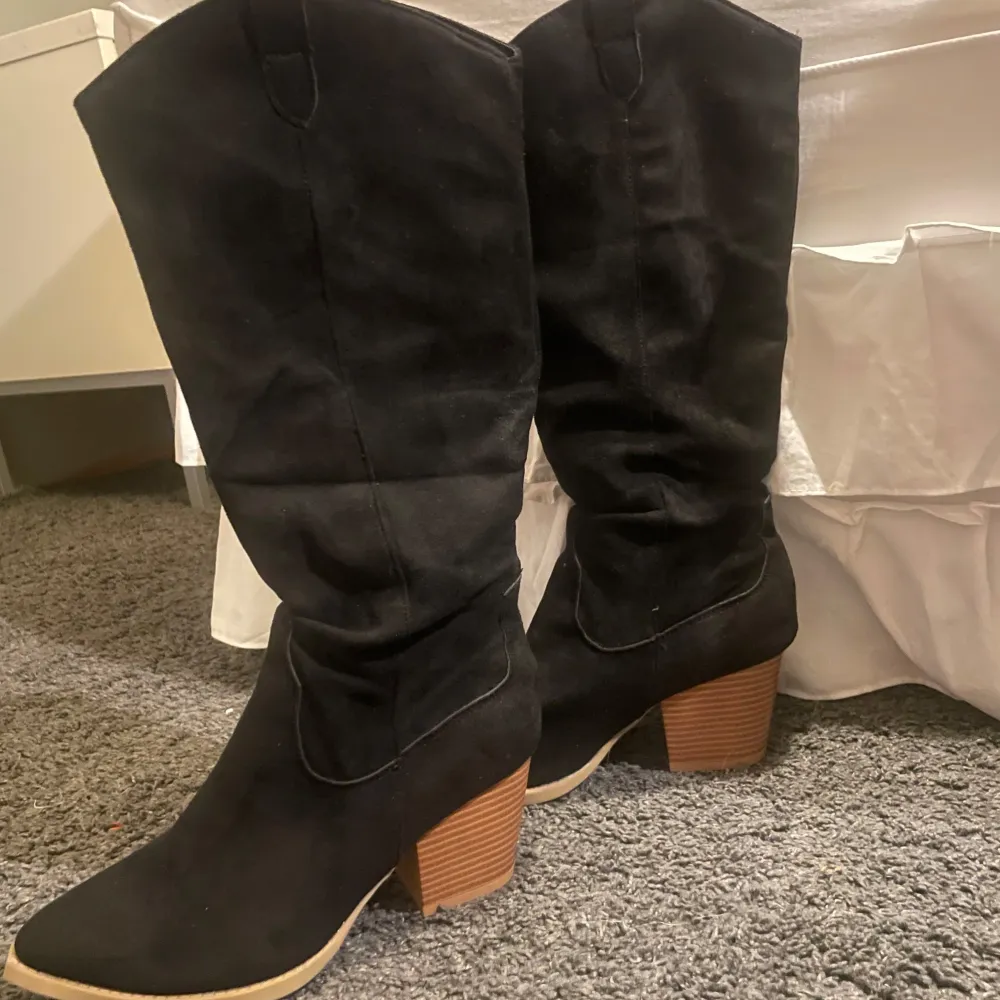 Snygga svarta stövlar i mocka med en rejäl klack. Perfekta för höst och vinter, dessa boots har en spetsig tå och ger en elegant look. De är i mycket bra skick och passar perfekt till både vardag och fest. Köpte eftersom att de var svin snygga men jag aldrig fått ett tillfälle att använda de, alltså är de aldrig använda!💗. Skor.