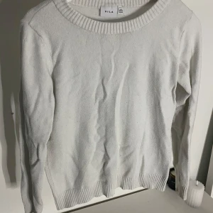 Vit tröja från VILA - Säljer en stilren vit tröja från VILA i storlek M. Tröjan är långärmad och har en ribbad kant vid halsen och ärmsluten. Perfekt för både vardag och lite kyligare dagar. Passar bra till jeans eller kjol för en avslappnad look.