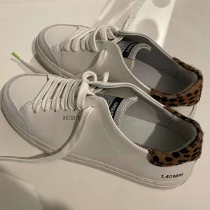 Snygga vita sneakers från Axel Arigato i skinn med  leoparddetaljer på hälen. Finns även ett till par jag säljer som är strolek 38!