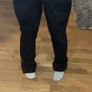 Svarta kostymbyxor från Bik Bok - Snygga randiga svarta kostymbyxor från Bik Bok med diskreta ränder. Perfekta för en stilren look. Byxorna har en klassisk passform och är tillverkade i ett bekvämt material.