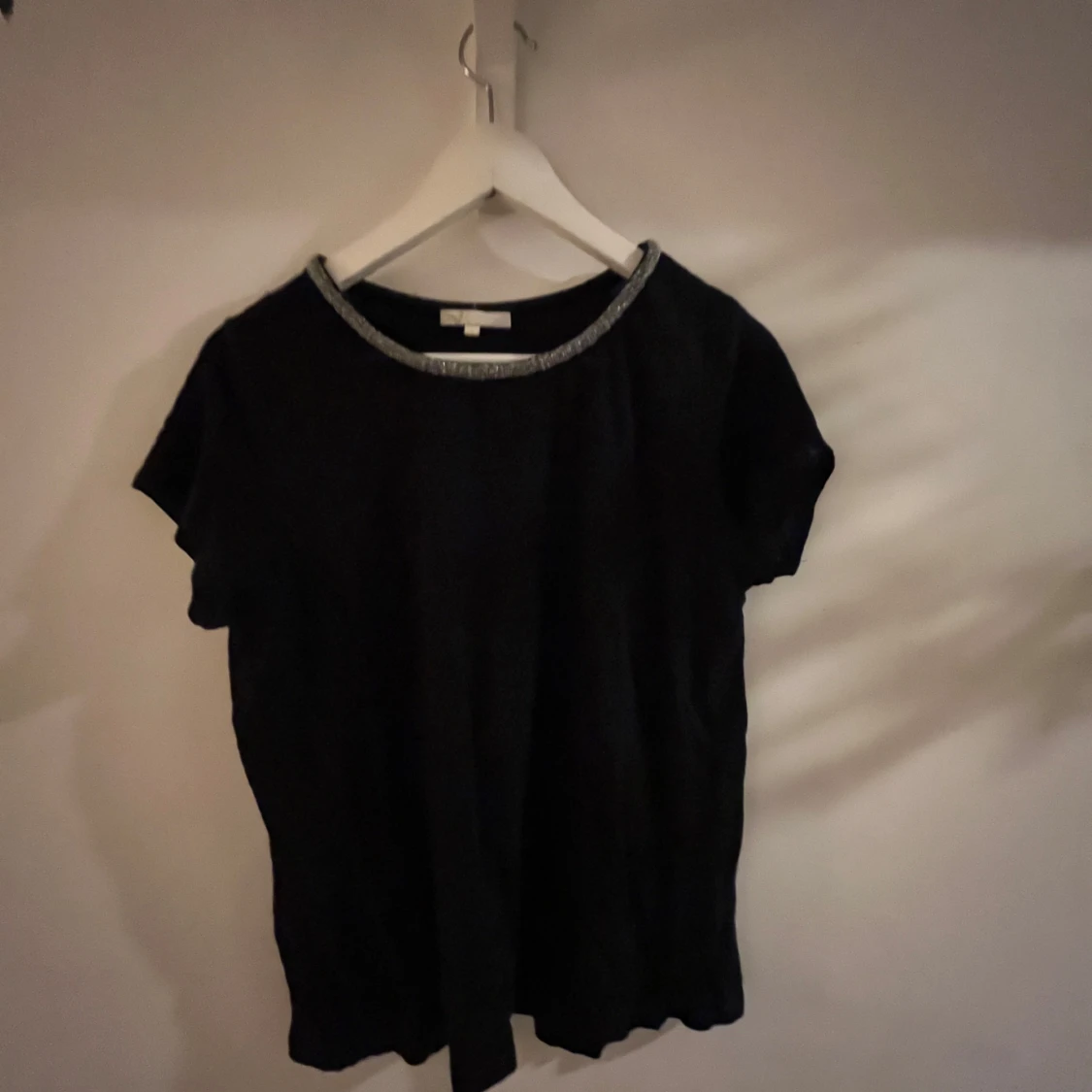 Svart topp med glittrig halsringning