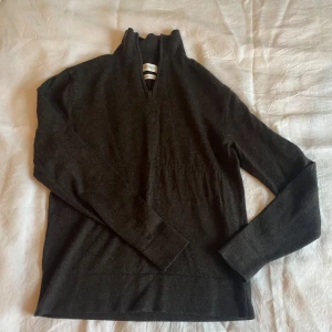 Mörkgrå tröja från These Glory Days - Säljer en stilren mörkgrå tröja från These Glory Days i Superior Merino ull. Tröjan har en dragkedja vid halsen och långa ärmar, perfekt för kyligare dagar. Den är mjuk och bekväm att bära och håller värmen bra.👍🏽