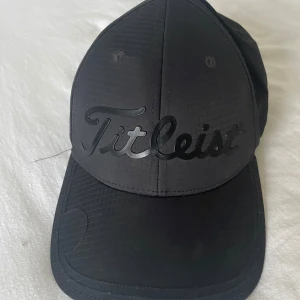 Svart keps från Titleist - Snygg svart keps från Titleist med broderad logga framtill. Perfekt för golfbanan eller vardagsbruk. Justerbar passform för optimal komfort.