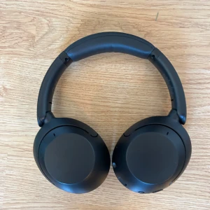 Hörlurar från Sony: Sony WH-XB910N - Säljer ett par svarta trådlösa hörlurar med bekväma öronkuddar och justerbart huvudband. Hörlurarna kommer med ett praktiskt fodral och laddsladd. Bra ljudkvalitet och utmärkt brusreducering. 