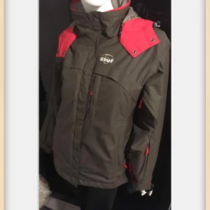 Grön  jacka från Stuf - Säljer en grön jacka från Stuf med rosa detaljer och huva. Jackan har flera praktiska fickor..varav en har karbinhake. Innerficka med uttag för hörlurar! 😊