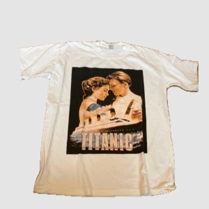 Vintage Titanic t-shirt - Cool vintage t-shirt med ett tryck av Titanic på framsidan. Perfekt för filmälskare som vill ha en unik stil. T-shirten har korta ärmar och en normal passform. 100% bomull