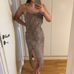 Leopardmönstrad klänning med slits - MANGO leopardmönstrad midi klänning med smala axelband och slits framtill. Strl medium.