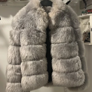 Pälsjacka - Säljer en lyxig och fluffig grå pälsjacka från Dennis Maglic. Jackan är tjock och håller en mycket varm nu under vintern. Den passar perfekt för nyårsfirandet! Jätte fin jacka som tyvärr aldrig kommit till användning. (Pris kan diskuteras vid snabb köp)