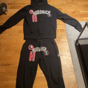 Hoodrich Set - Säljer en svart hoodie från Hoodrich med stora vita och röda tryck på framsidan. Hoodien har en klassisk design med huva och känguruficka. Perfekt för en avslappnad stil. 800 för hela sättet.