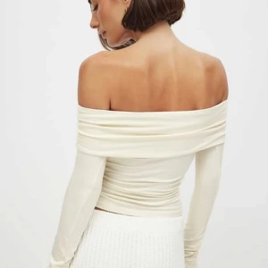 Krämfärgad offshoulder topp - Elegant krämfärgad offshoulder topp med långa ärmar. Perfekt för en stilren look, med en åtsittande passform som framhäver axlarna. Tillverkad i ett mjukt och stretchigt material för extra komfort. Mycket smickrande. Endast använd 1 gång. Nypris 299 kr , mitt pris 249 kr. Lägg gärna prisförslag.