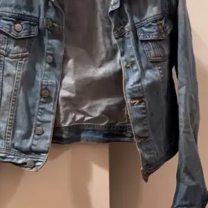 Snygg blå jeansjacka från Cdenim med klassisk design och knappar framtill. Jackan har två bröstfickor med lock och en stilren krage. Perfekt för en avslappnad look.