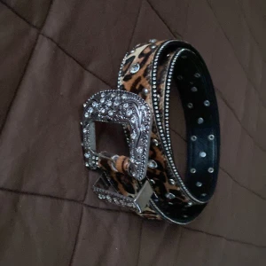 Leopardmönstrat bälte med strassdetaljer från Zara - Snyggt leopardmönstrat bälte från Zara med glittrande strassdetaljer och en dekorativt utsmyckad spänne i silverfärg. Perfekt för att ge en extra touch till din outfit. 🐆✨