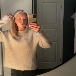 Beige stickad tröja - Mysig beige stickad tröja med långärmad design. Perfekt för kyligare dagar och ger en avslappnad look.