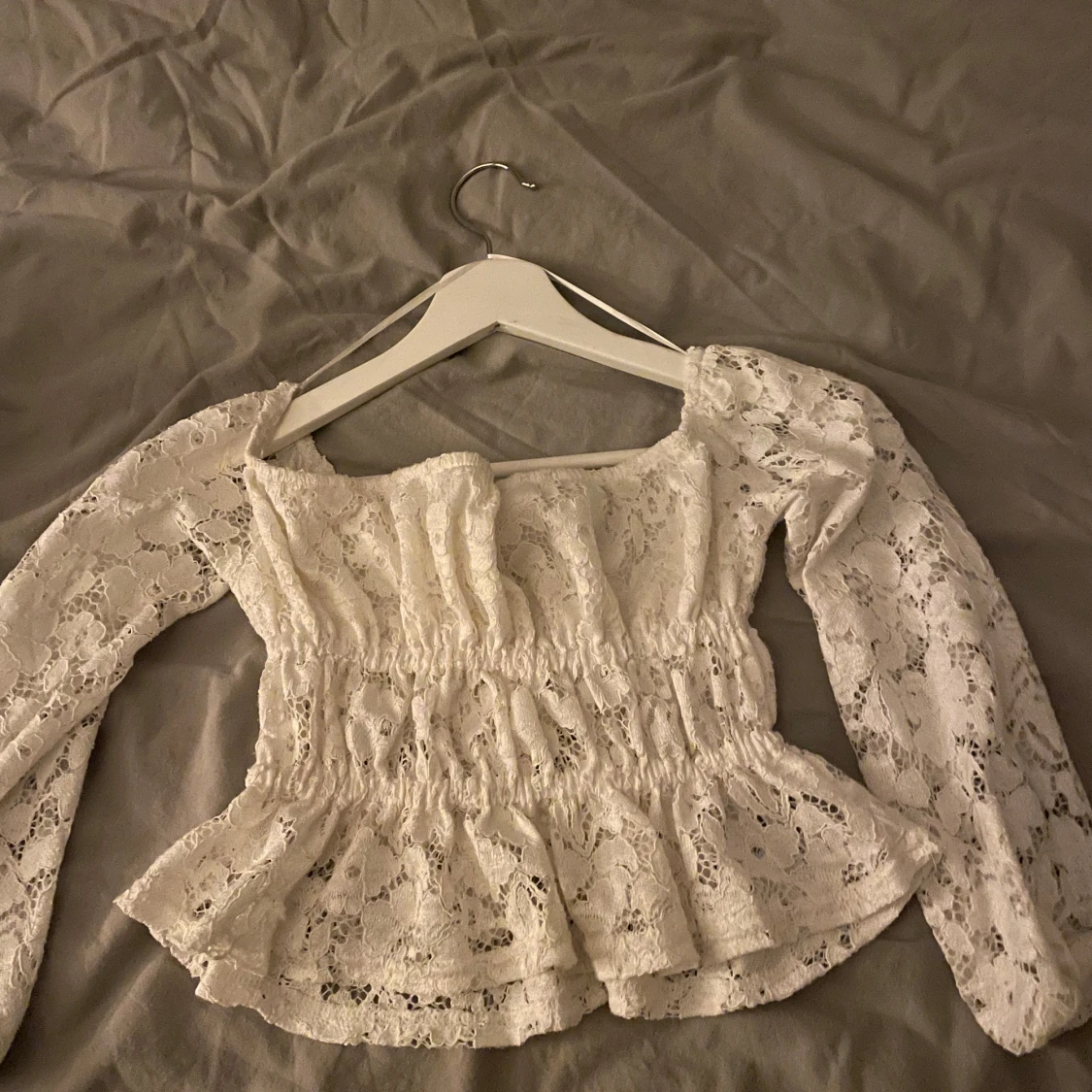 Vit spetsblus med volangdetaljer