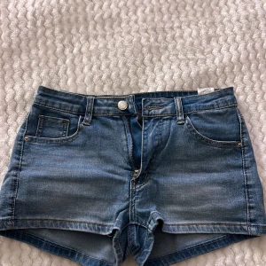Blå jeansshorts från Shein - Snygga blå jeansshorts från Shein i en klassisk design med fem fickor och knappgylf. Perfekta för sommardagar och enkla att matcha med olika toppar.