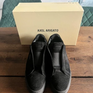 Svarta Axel Arigato Clean 360 Laceless - Snygga svarta Axel Arigato Clean 360 Laceless sneakers utan snörning. Perfekta för en stilren look med en bekväm passform. Skorna har en diskret design med en slitstark sula. Köpta på NK för 2500:- Använda endast 1 gång. Kvitto saknas tyvärr då både grabben och jag skyller på varandra att vi gav det till den ena 🥹Låda & dustbag finns iaf .. 