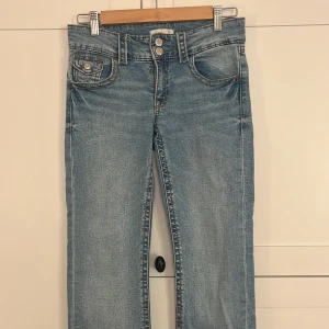 Blå jeans från Gina Tricot - Snygga ljus blåa jeans från Gina Tricot med dubbla knappar.