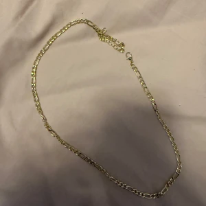 Guldfärgat halsband - Elegant guldfärgat halsband med en klassisk kedjedesign. Perfekt för att lägga till en touch av stil till vilken outfit som helst. Passar både till vardag och speciella tillfällen.