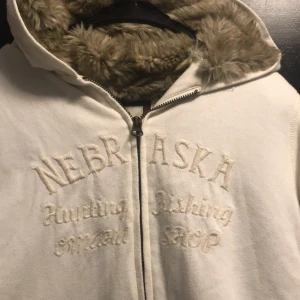 Vit hoodie med pälsfoder  -  Mysig pälsfodrad insida och dragkedja framtill. Perfekt för kyliga dagar! Något nopprig  på utsidan men inget som stör, annars i bra skick. Pälsfodret är i nyskick och sååå mjukt. Storleken är large men passar även bra om du vanligtvis har medium.