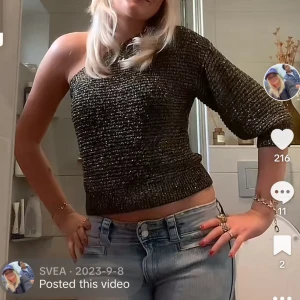 Svart glittrig oneshoulder topp - Snygg svart glittrig oneshoulder topp som är croppad. Perfekt för en festlig kväll. Toppen har en tight passform och ger en trendig look.